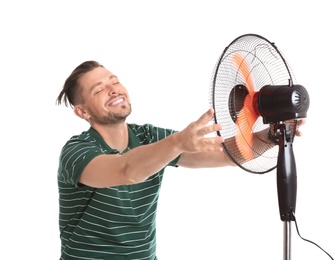 Photo of Man refreshing from heat in front of fan on white background