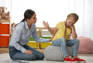 Photo of Child psychotherapist working with little girl in office