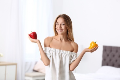 Happy slim woman with bell peppers at home. Weight loss diet