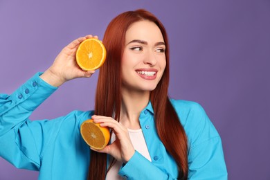 Photo of Happy woman with red dyed hair and oranges on purple background