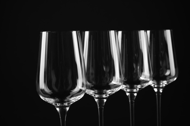 Photo of Set of empty wine glasses on black background