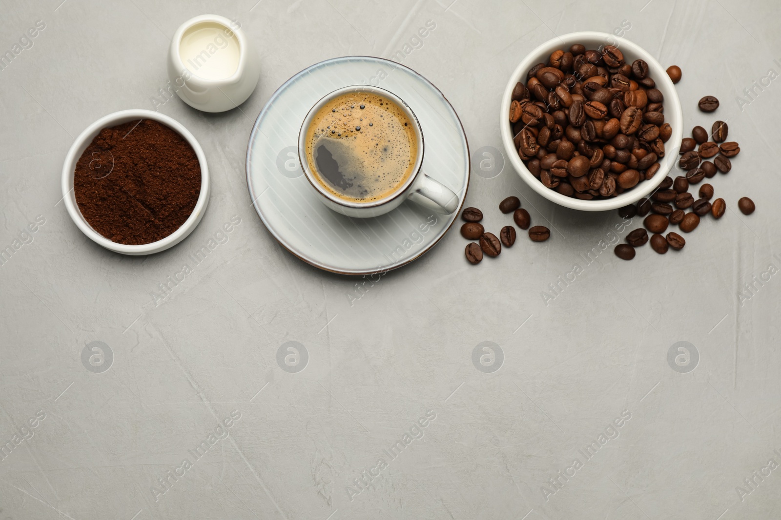 Photo of Flat lay composition with coffee grounds and roasted beans on light table, space for text