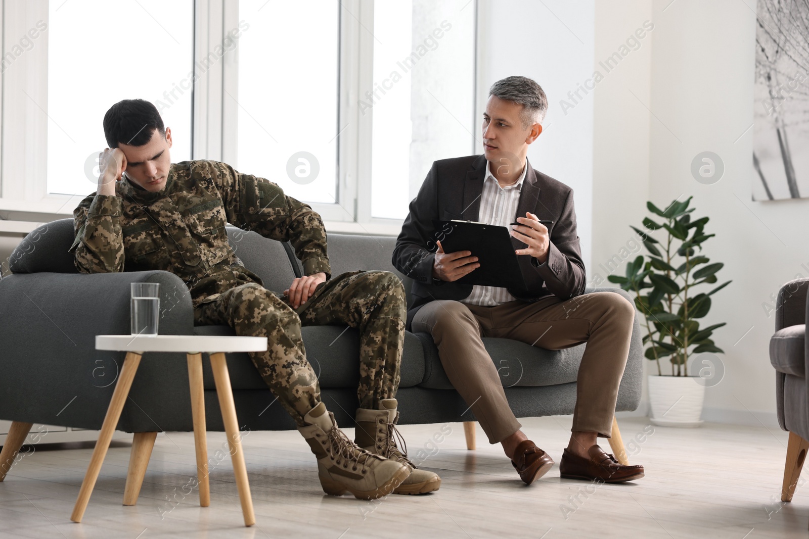 Photo of Professional psychotherapist working with military man in office