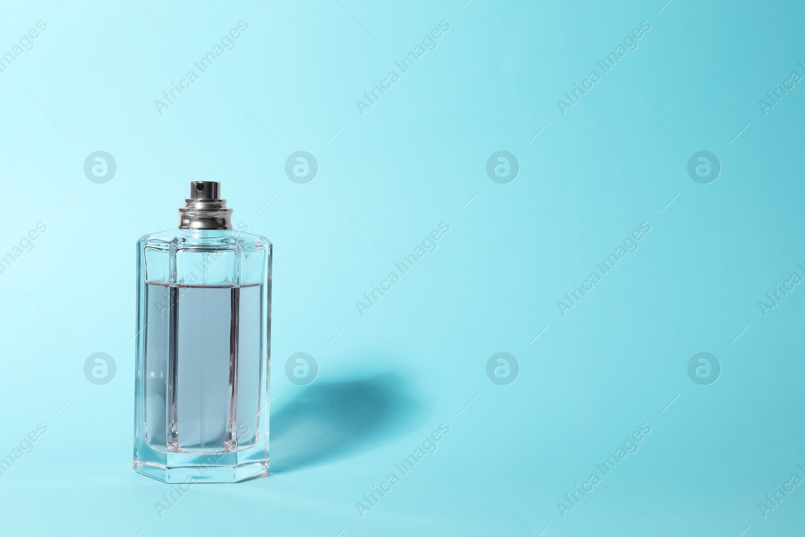 Photo of Bottle of perfume on color background