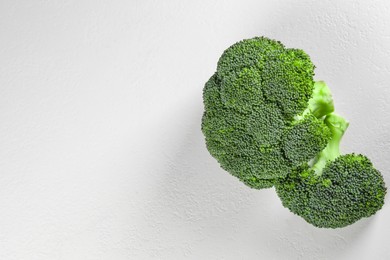 Fresh raw broccoli on white table, flat lay. Space for text