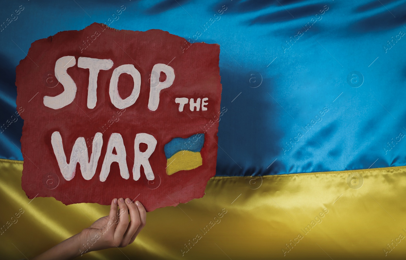 Photo of Woman holding poster with words Stop the War near Ukrainian flag, closeup. Space for text