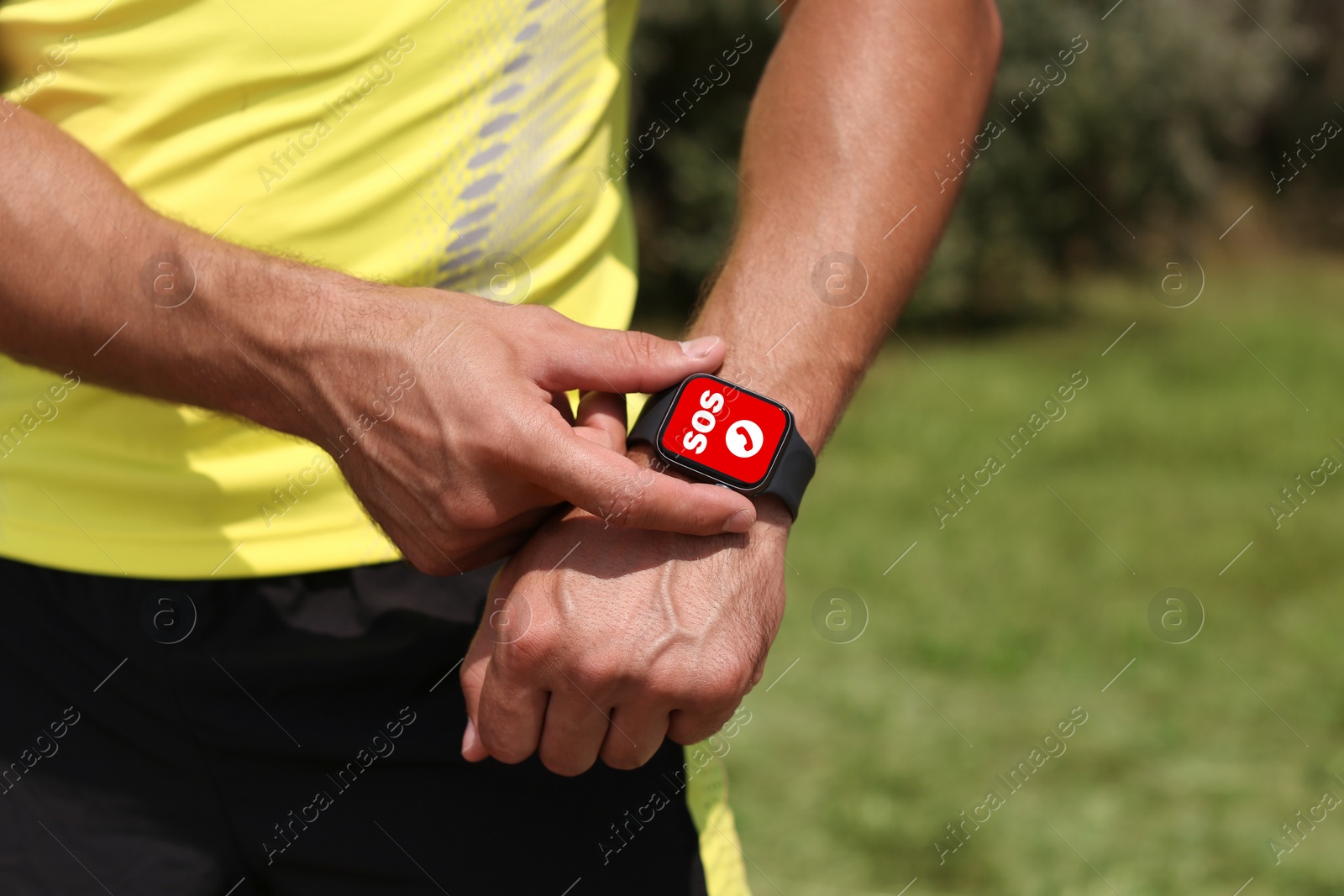 Image of Man using SOS function on smartwatch outdoors, closeup