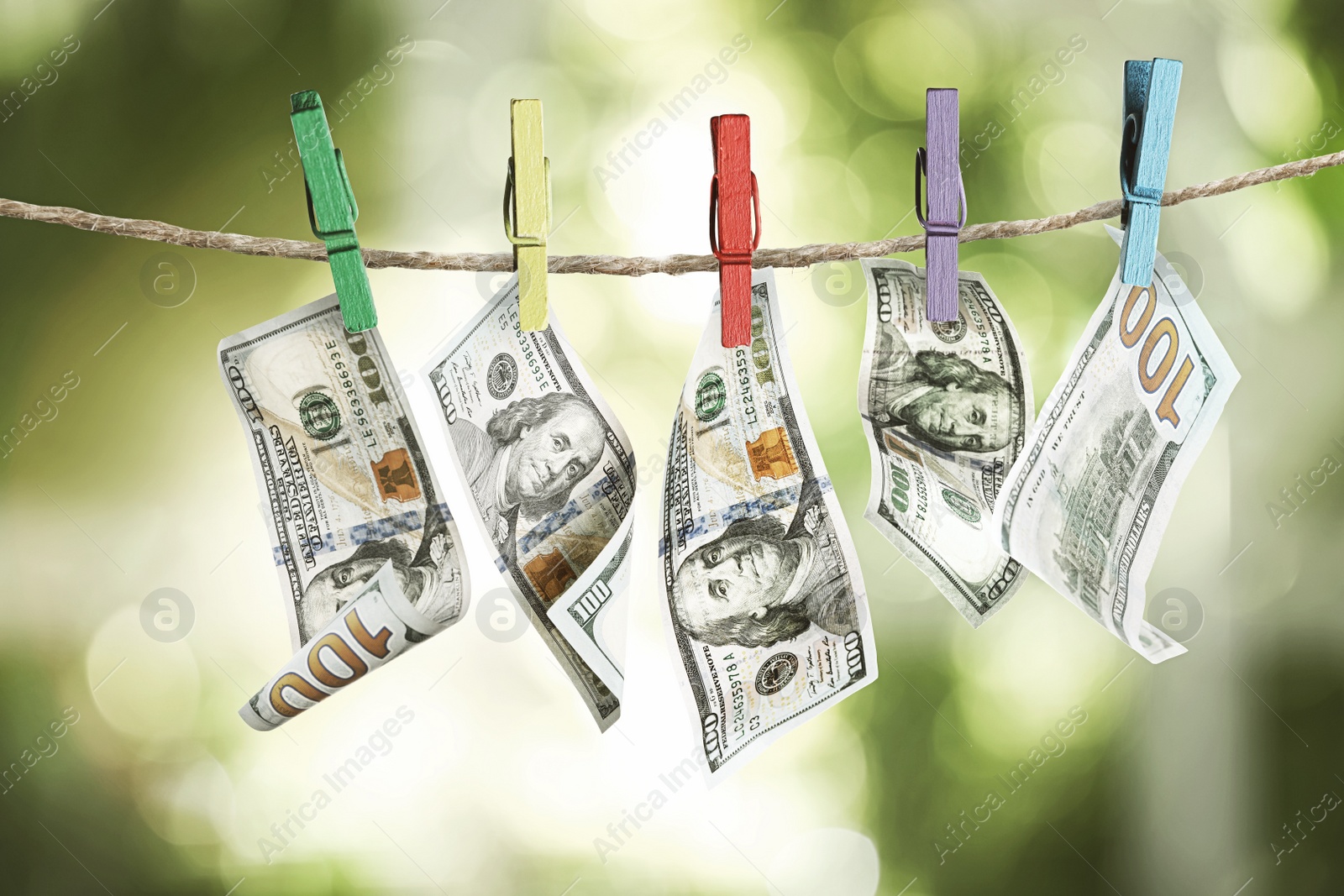 Image of Money laundering. Dollar banknotes hanging on clothesline outdoors