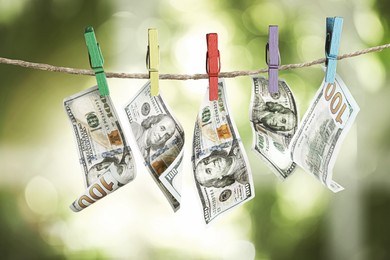 Image of Money laundering. Dollar banknotes hanging on clothesline outdoors