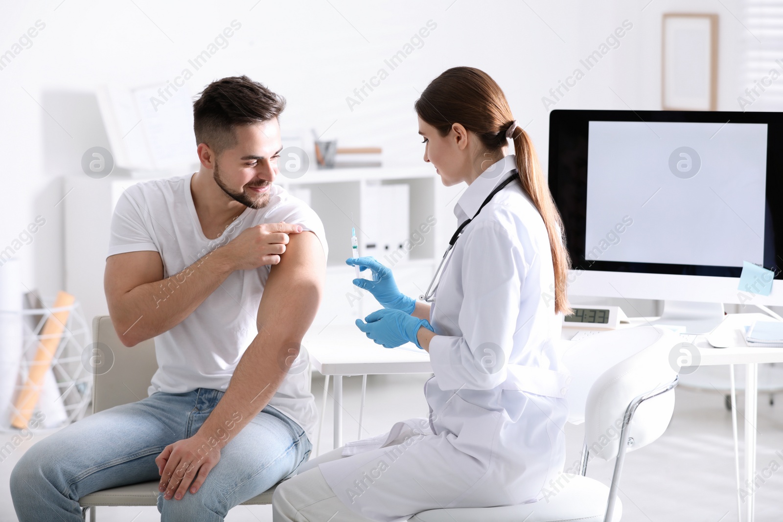 Photo of Doctor giving injection to patient in hospital. Vaccination concept