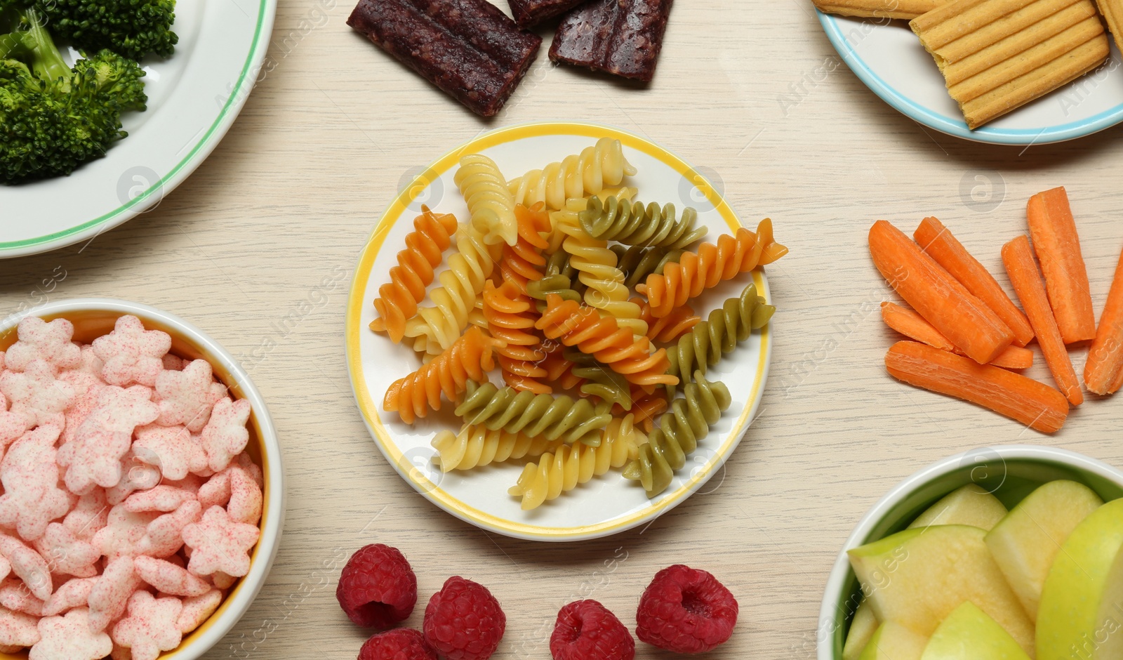 Photo of Set of different finger foods for baby on beige wooden table, flat lay