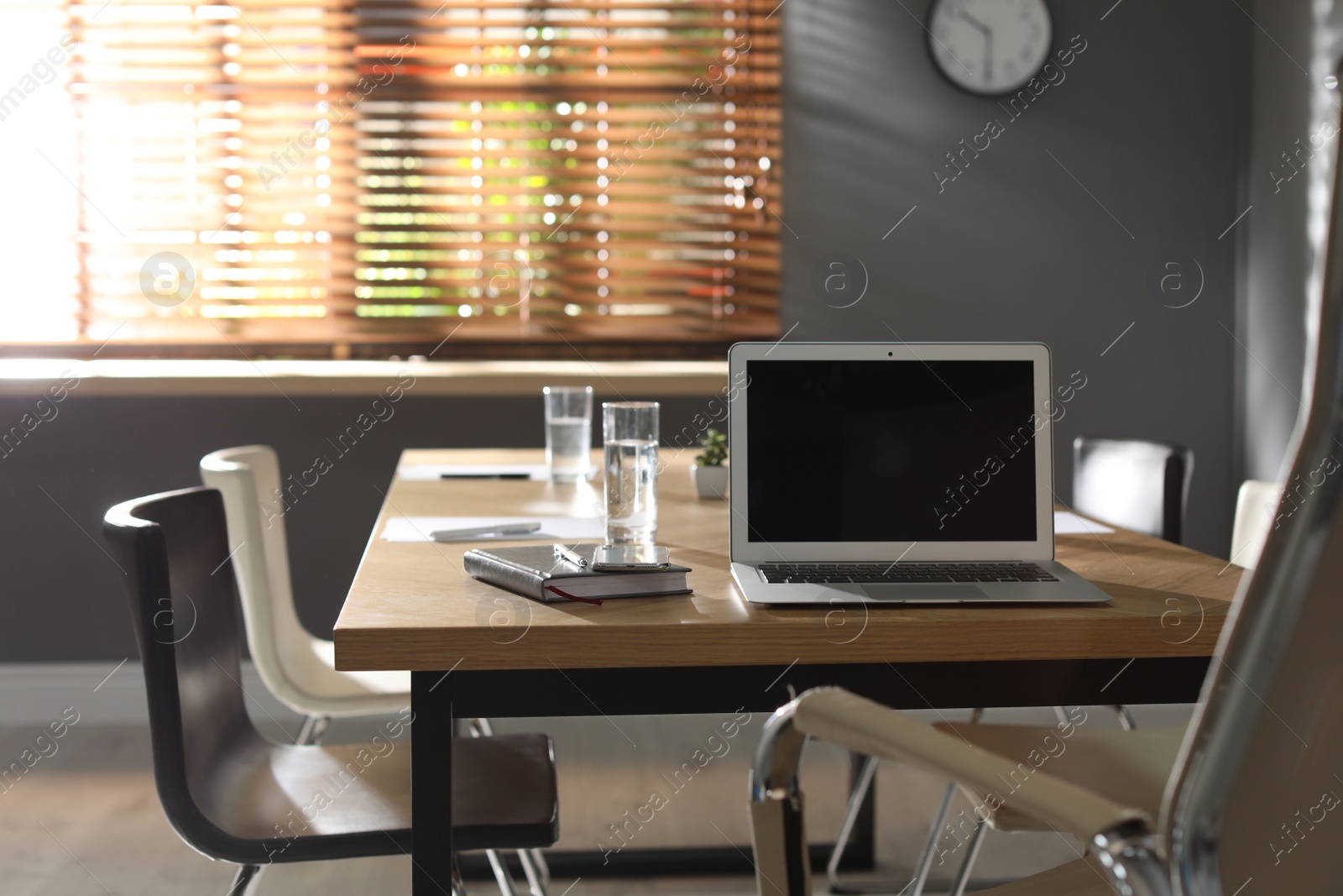 Photo of Laptop on wooden table in modern office