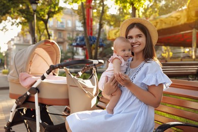 Photo of Happy mother with baby sitting on bench in park