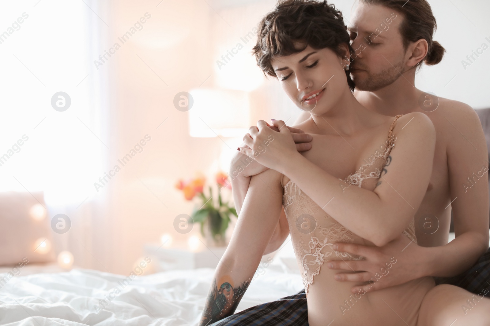 Photo of Lovely young couple being intimate on bed at home