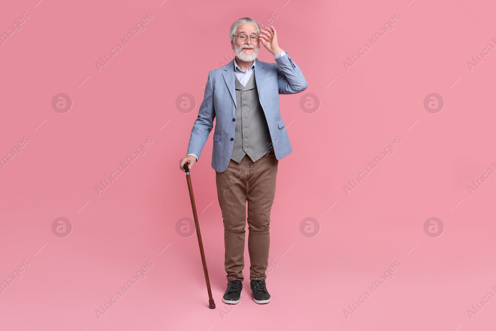 Photo of Senior man with walking cane on pink background