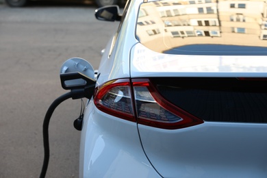 Photo of Charging modern electric car from station outdoors