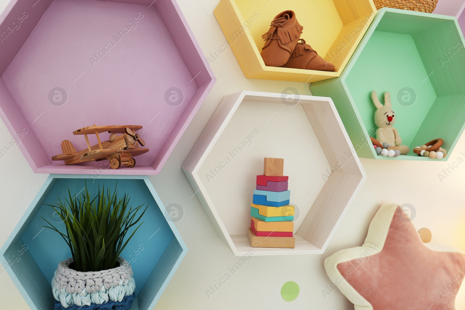 Photo of Bright colorful shelves on light wall. Interior design