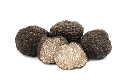 Photo of Cut and whole black truffles isolated on white