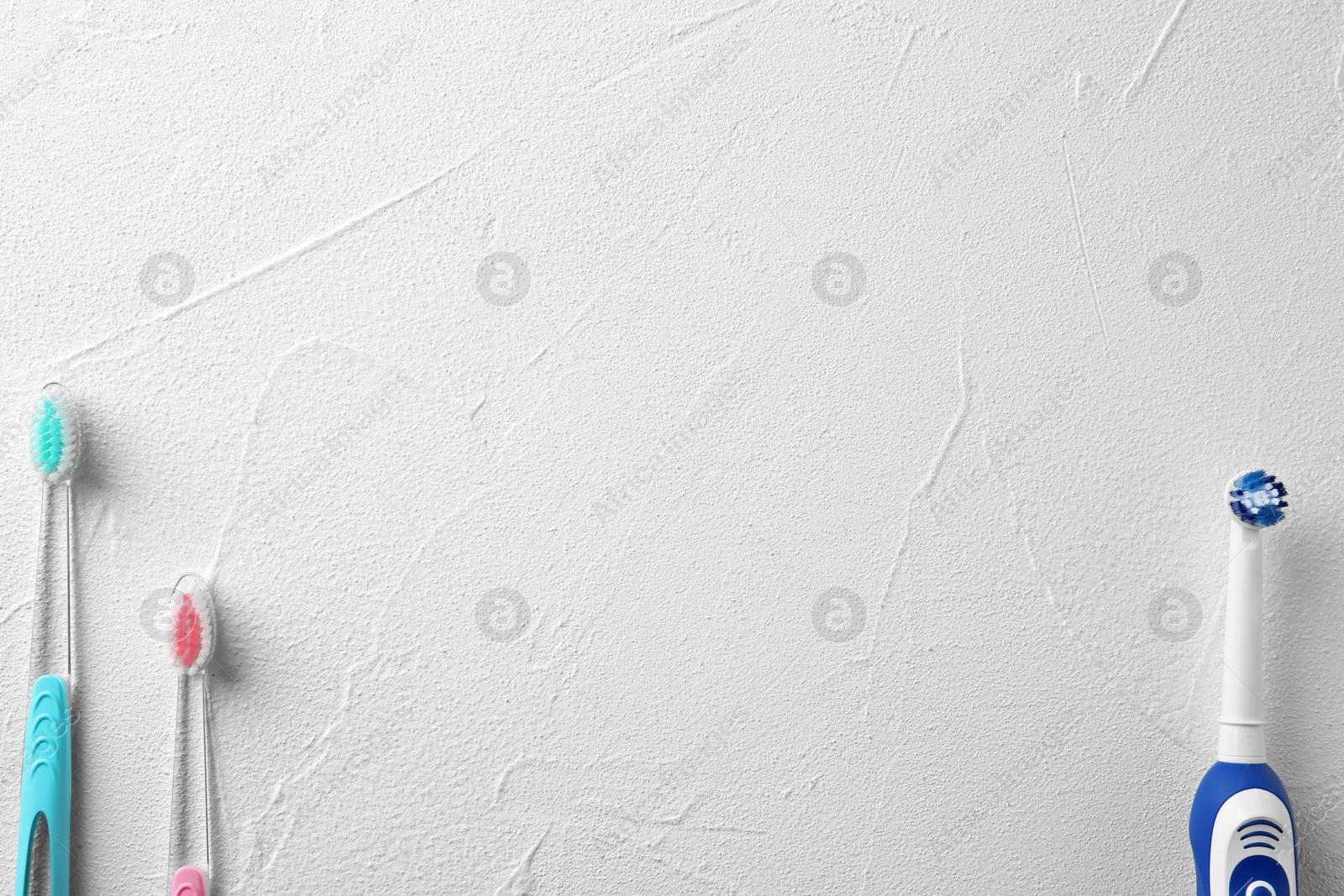 Photo of Electric and manual toothbrushes on light background