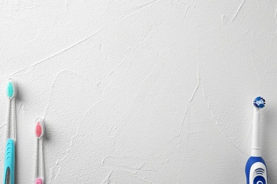 Electric and manual toothbrushes on light background