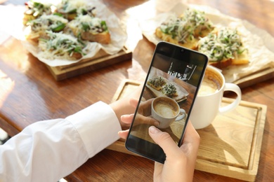 Photo of Food blogger taking photo of her lunch at cafe, closeup