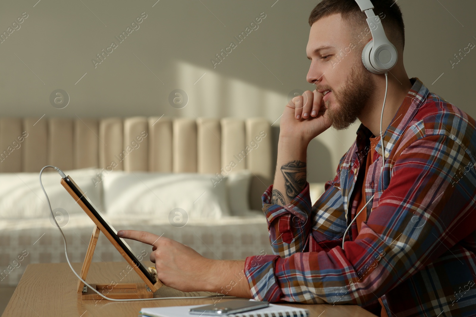 Photo of Online test. Man studying with tablet at home