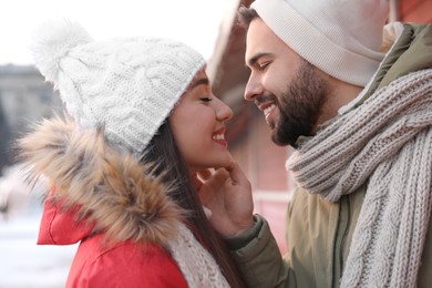 Happy young couple spending time together at winter fair. Christmas celebration