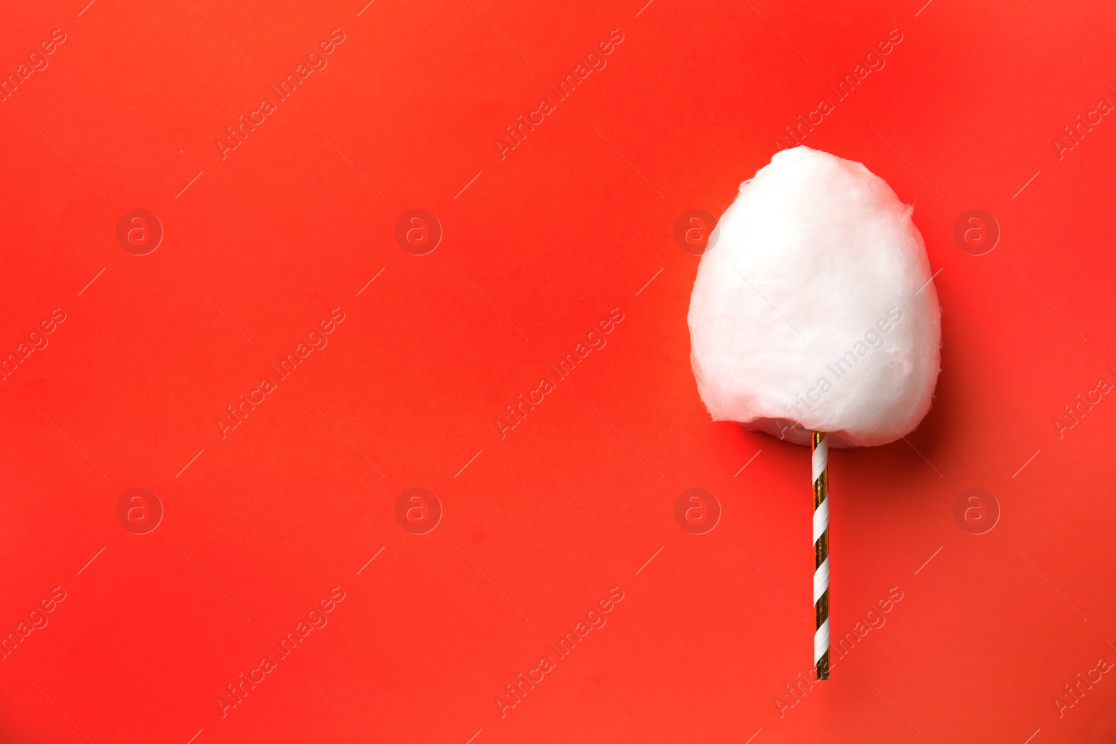 Photo of Straw with yummy cotton candy on color background, top view. Space for text