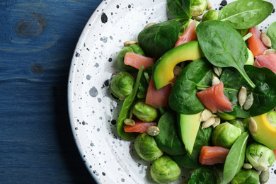 Photo of Tasty salad with Brussels sprouts on wooden table, top view