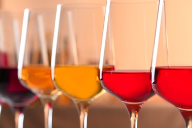 Photo of Row of glasses with different wines against blurred background, closeup