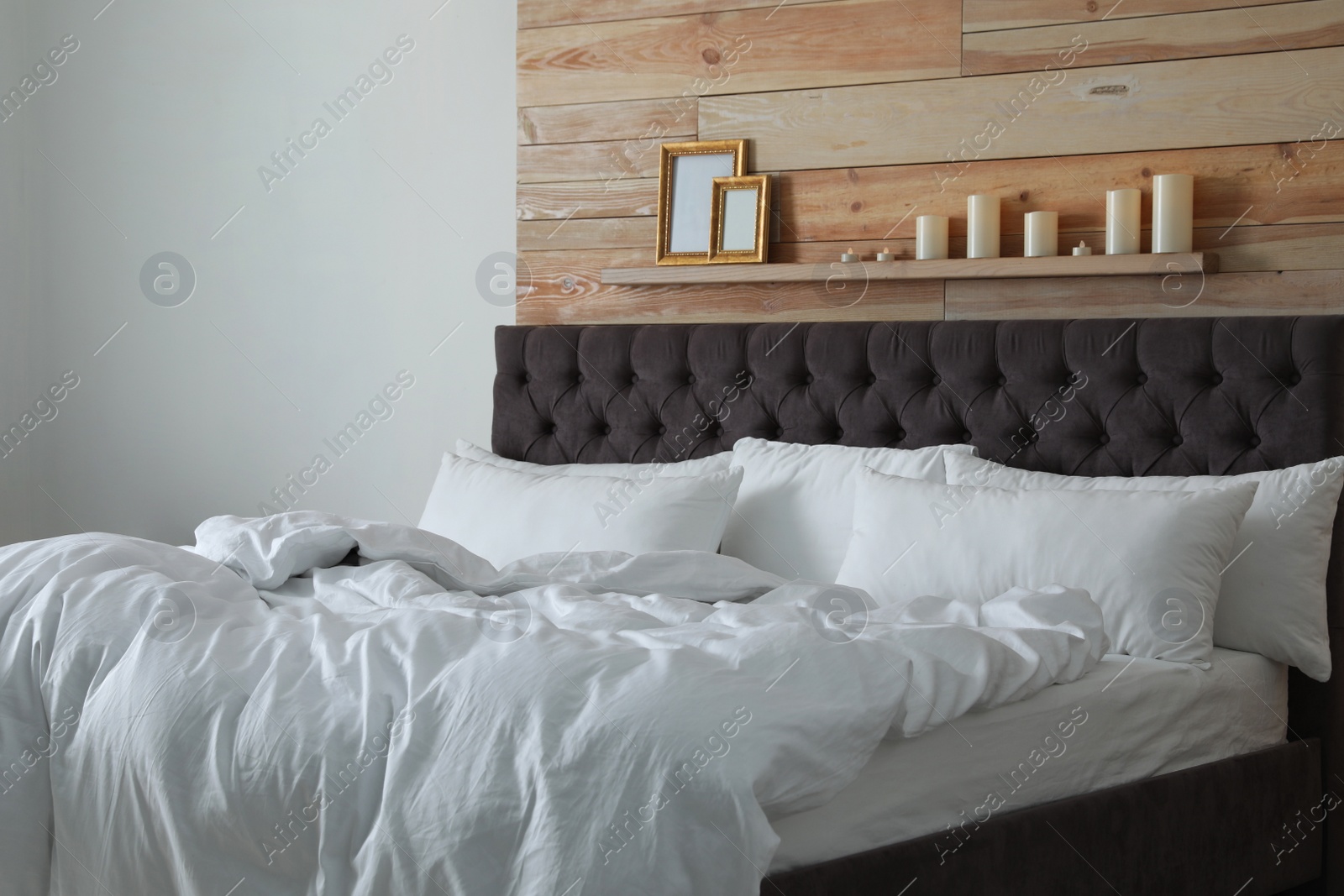 Photo of Large comfortable bed in stylish room. Modern interior design