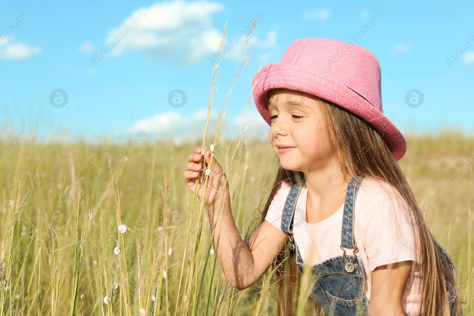 Photo of Cute little girl with spikes outdoors, space for text. Child spending time in nature