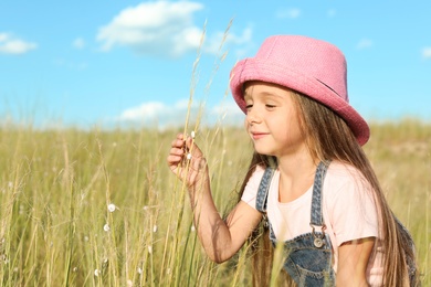 Photo of Cute little girl with spikes outdoors, space for text. Child spending time in nature