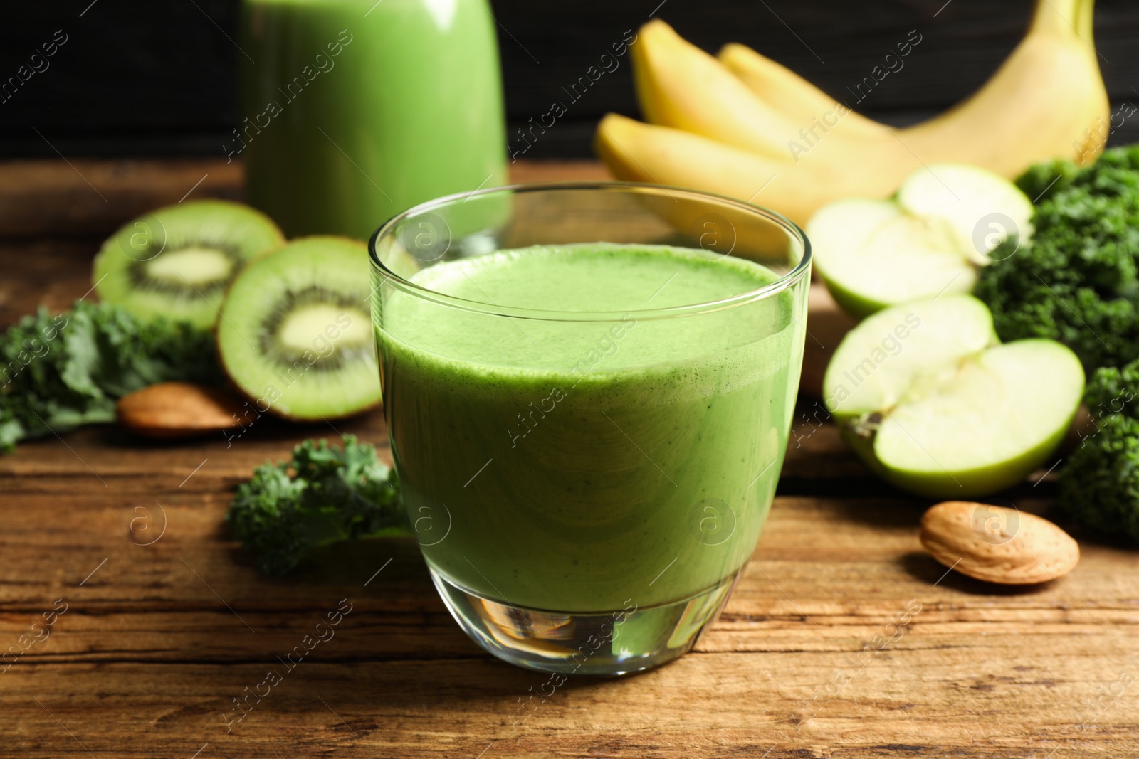 Photo of Tasty fresh kale smoothie on wooden table, closeup