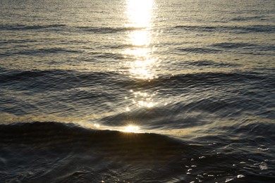 Photo of Rippled surface of sea at sunset as background