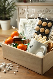 Photo of Crate with gift set and Christmas decor on wooden table
