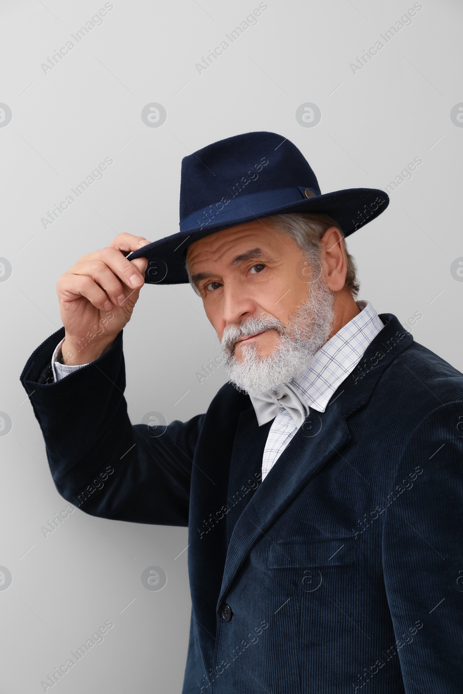 Photo of Attractive senior man in stylish hat on light background