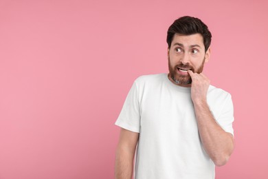 Portrait of surprised man on pink background, space for text