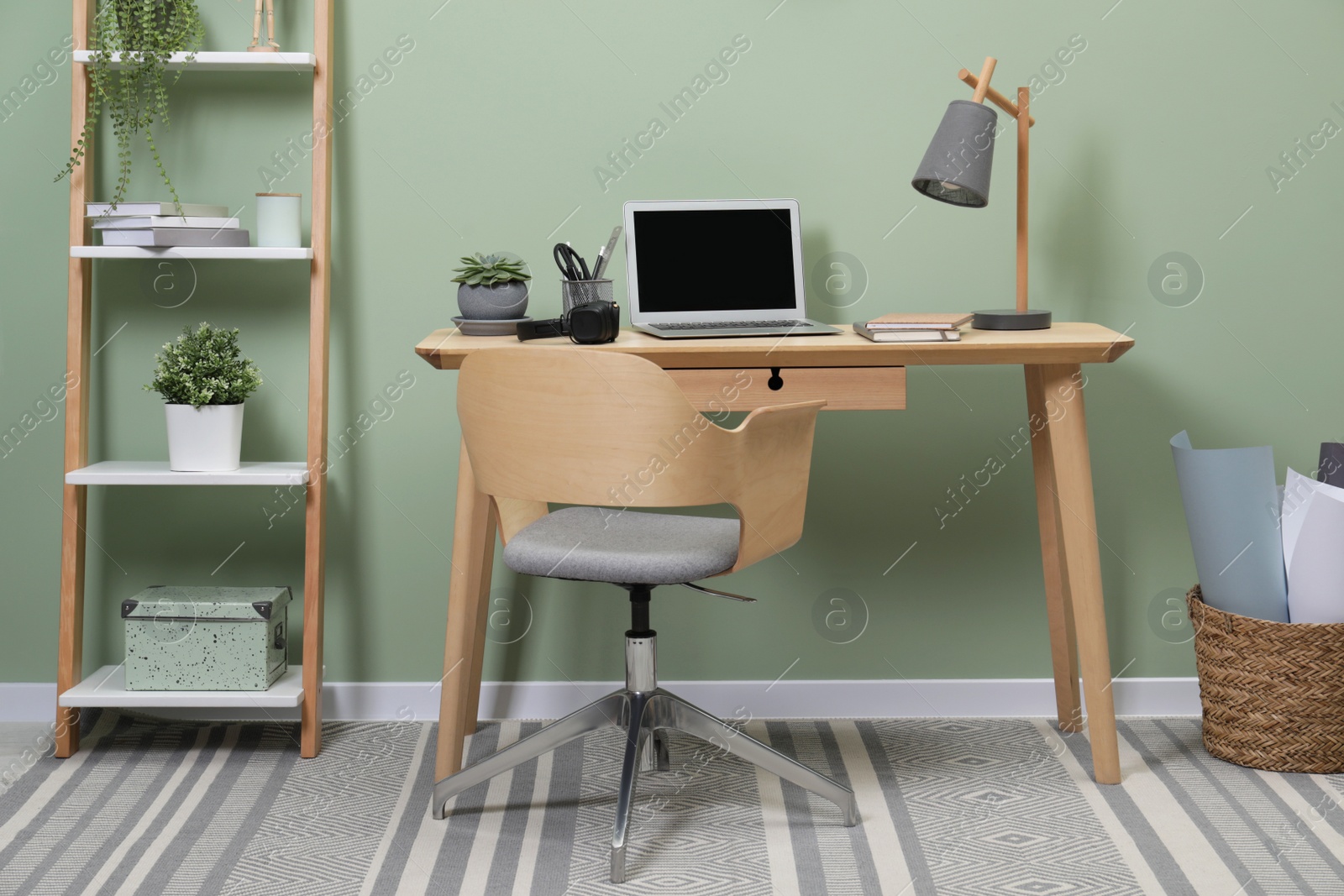 Photo of Workplace with laptop, stationery on desk and chair in home office