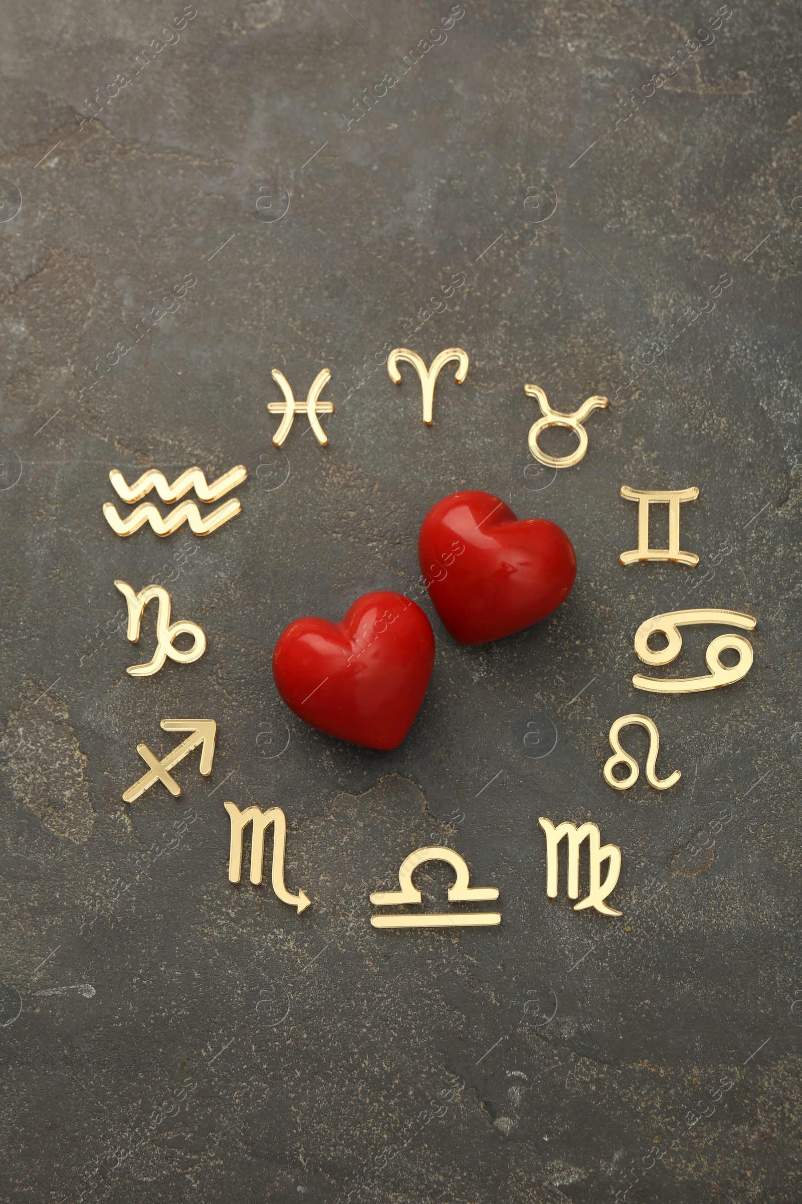 Photo of Zodiac signs and red hearts on grey textured background, flat lay