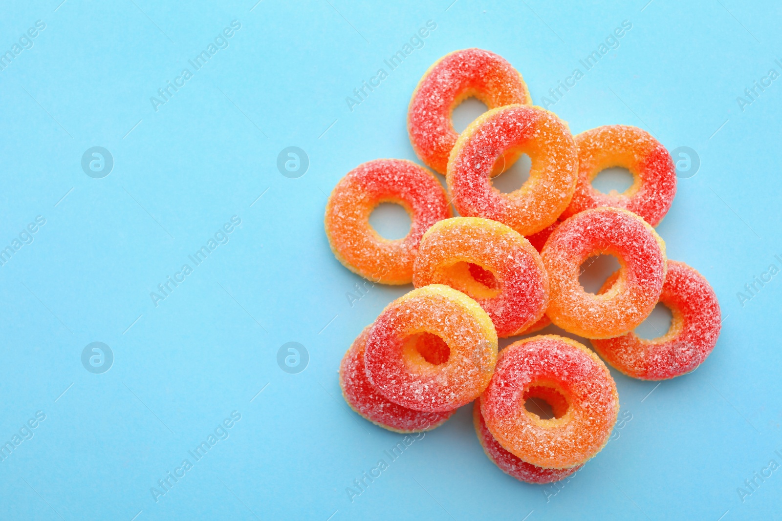Photo of Pile of tasty jelly candies on color background, top view with space for text