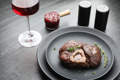 Photo of Tasty grilled beef meat served on black table