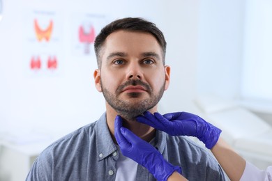 Photo of Endocrinologist examining thyroid gland of patient at hospital, closeup