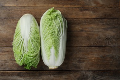Photo of Fresh ripe Chinese cabbages on wooden table, fat lay. Space for text