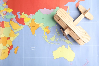 Photo of Toy airplane on world map, top view. Travel agency
