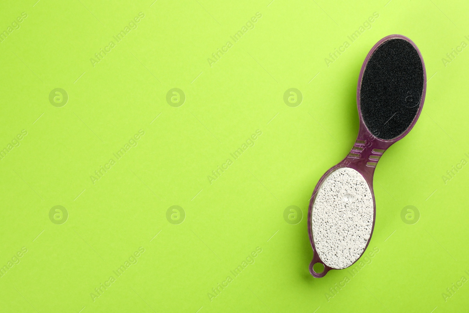 Photo of Pedicure tool with pumice stone and foot file on green background, top view. Space for text