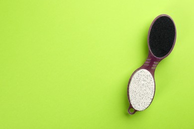 Photo of Pedicure tool with pumice stone and foot file on green background, top view. Space for text