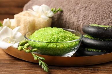 Aromatic sea salt and spa products on wooden table, closeup