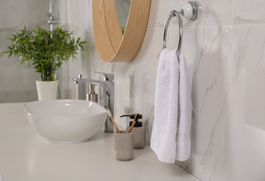 Soft towel on wall above bathroom countertop with toiletries