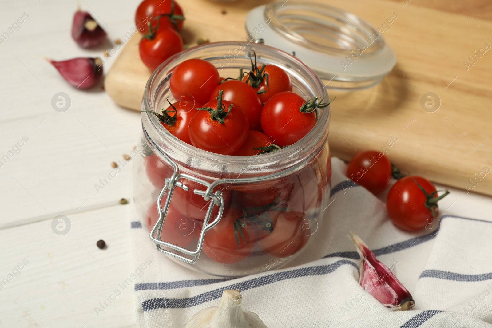 Photo of Pickling jar with fresh ripe cherry tomatoes and spices on white wooden table
